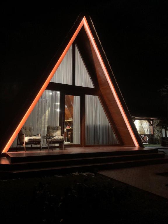a house with a triangular roof with two chairs at Sayat Nova Home in Dilijan