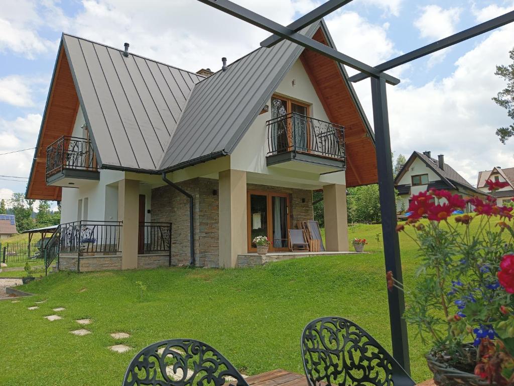 a house with a metal roof on a yard at Będzie Fajnie in Poronin