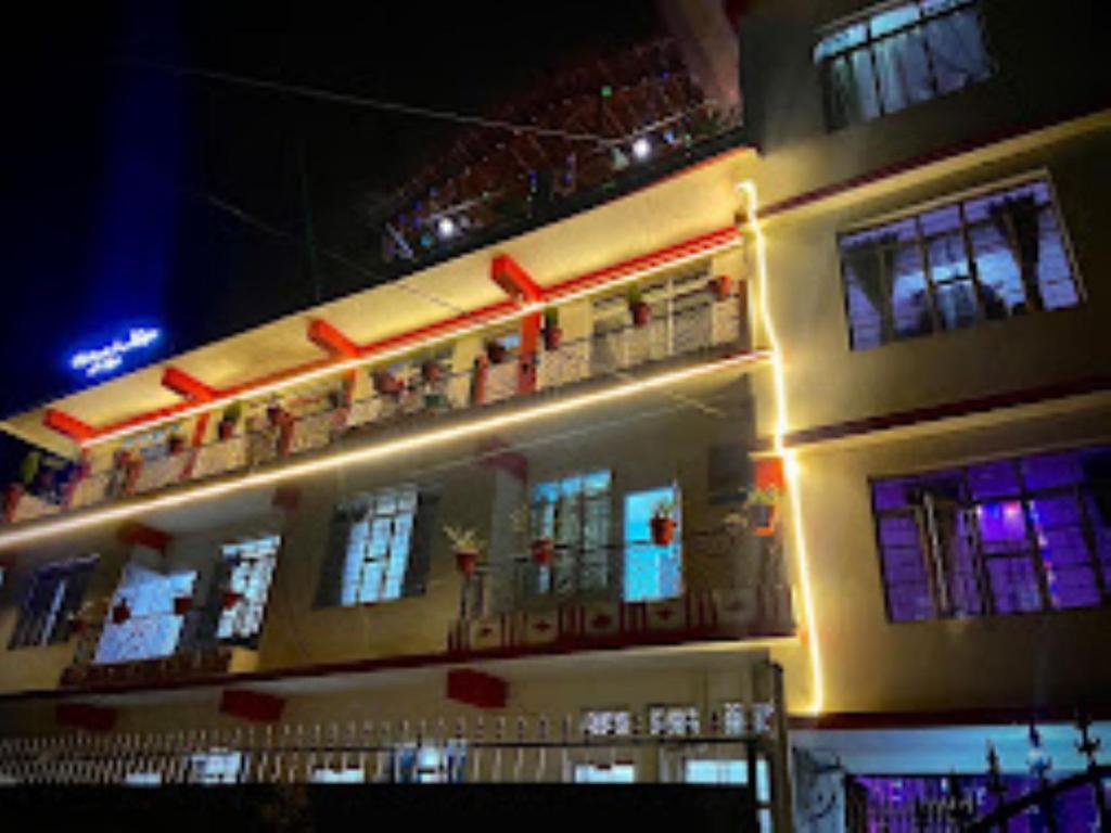 a building with lights on the side of it at night at Winnie's Lodge , Shillong in Shillong