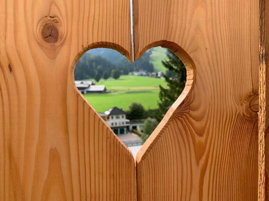 um buraco em forma de coração numa cerca de madeira em Herzzeit Apartments em Flachau