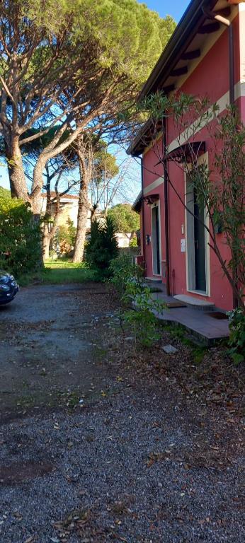 uma casa vermelha com árvores em frente em La Casa sull'argine 2 em Sarzana