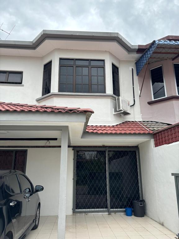 a house with a car parked in front of it at Homestay Hajrah in Ipoh