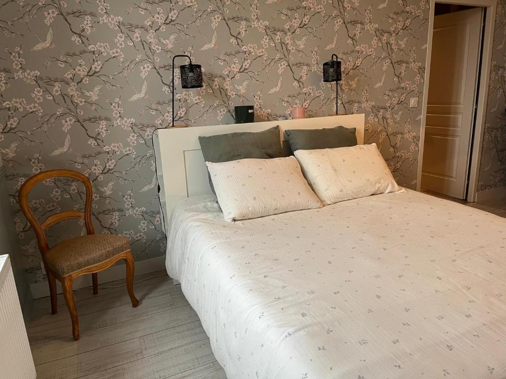a bedroom with a white bed and a chair at Chambre d'hôtes de La Clie in Saint-Michel-de-Fronsac