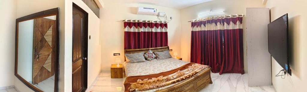 a bedroom with a bed and red curtains at Bethel House Holiday Stay-inn in Alibaug