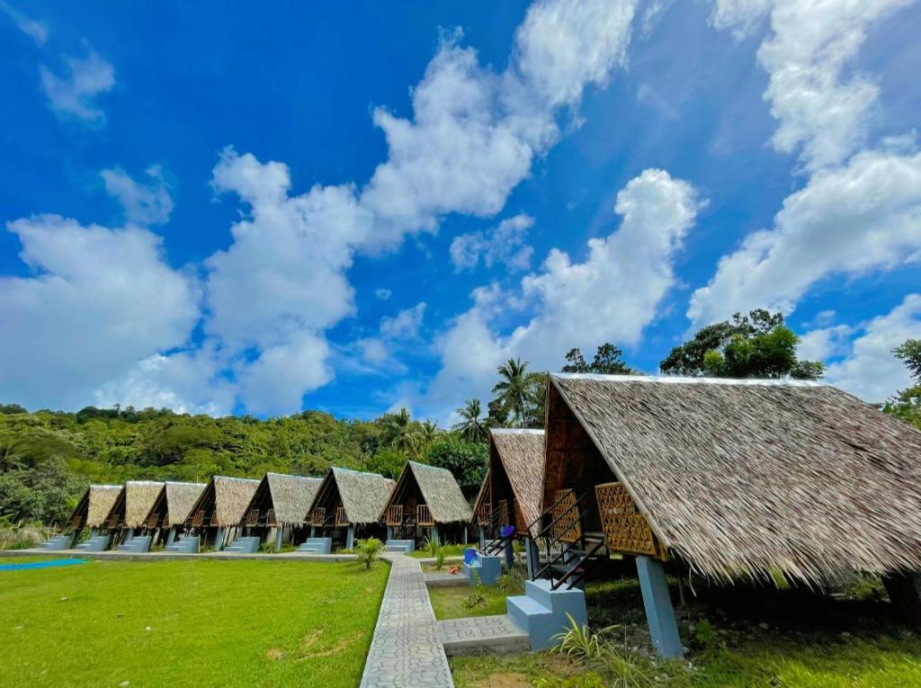 uma fila de cabanas num resort com um céu azul em Enchanting Paraw Resort - Fan Room em Boracay
