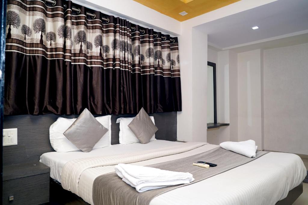 a bedroom with a bed with white towels on it at Balaji Hotel in Ahmedabad