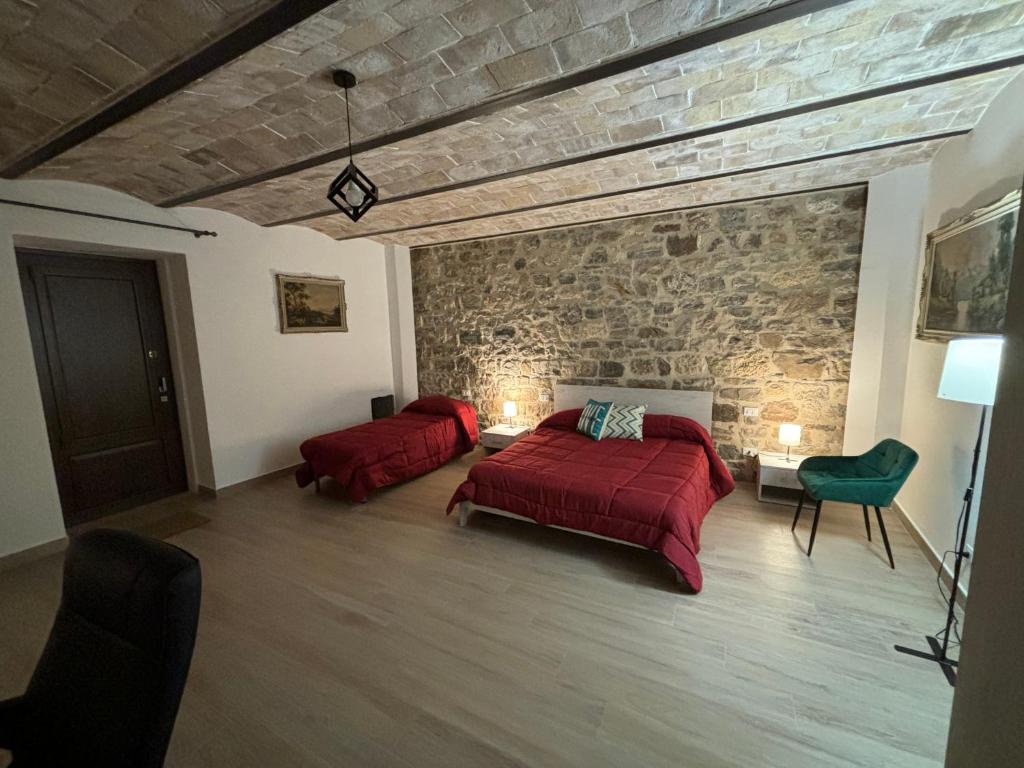 a bedroom with two beds and a stone wall at Dream House Castellana in Castellana Sicula