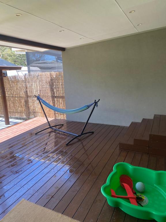 a hammock on a wooden floor in a room at OAK FLATS - Cosy Getaway in Lake Illawarra