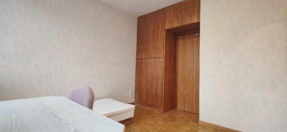 a bedroom with a bed and a wooden cabinet at Cosy Room in Pātan