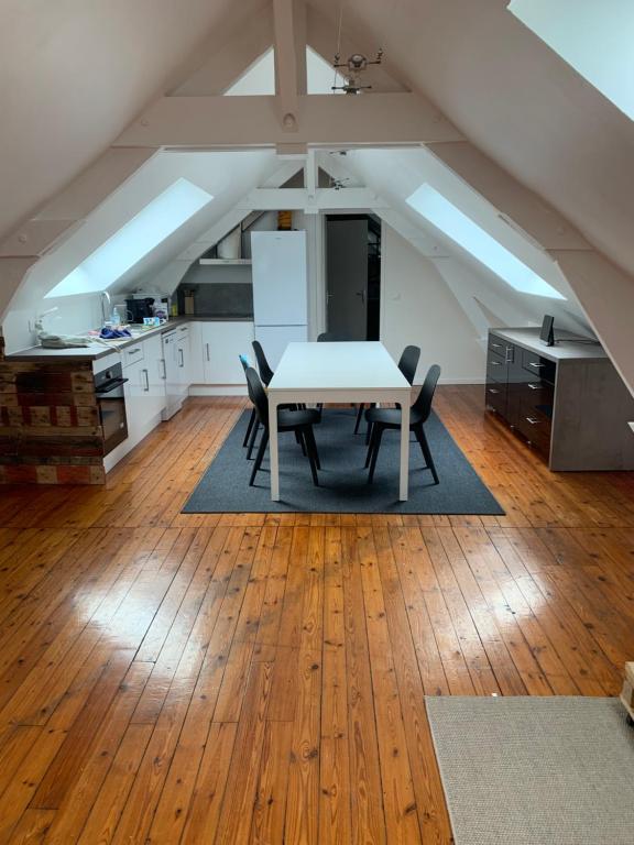 een keuken met een tafel en stoelen in een kamer bij Loft au calme, idéal pour famille, proche de Reims in Saint-Brice-et-Courcelles