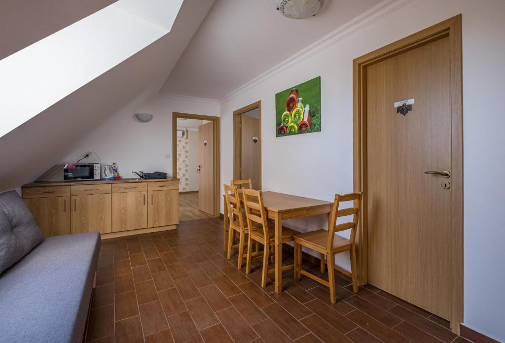 a kitchen and dining room with a table and chairs at Dobosi Vendégház in Szentantalfa