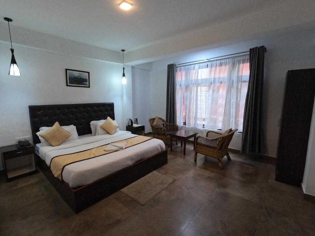 um quarto com uma cama grande e uma janela em Hotel Rainbow em Gangtok