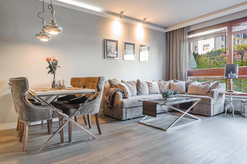 a living room with a couch and a table at La Bagatelle by Baltica Apartments + parking in Sopot