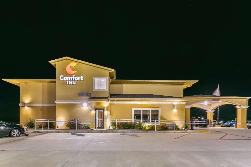 een geel gebouw met een auto op een parkeerplaats bij Comfort Inn US 60-63 in Willow Springs