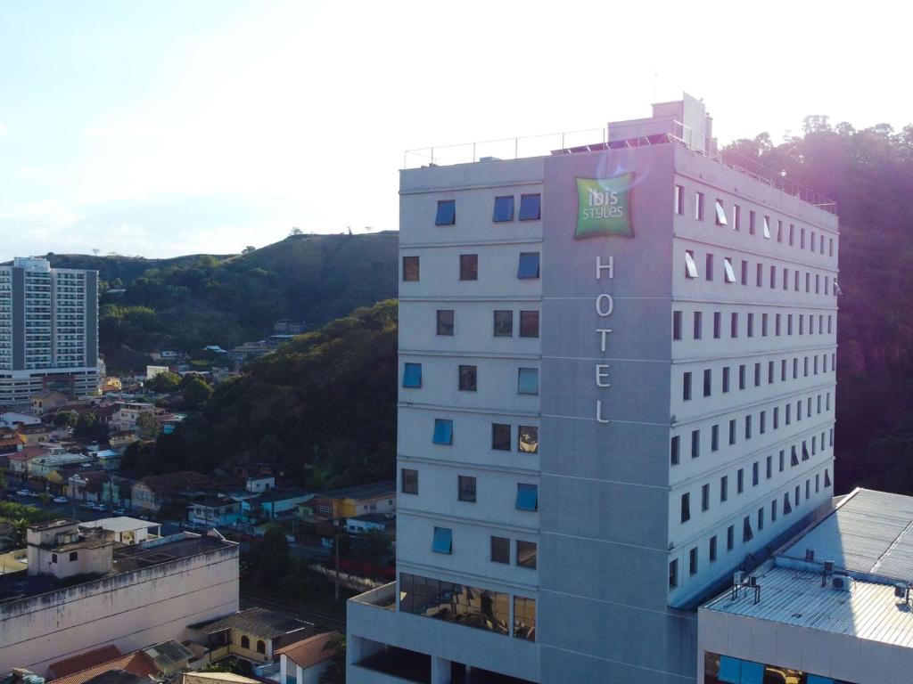 a tall white building with a sign on it at ibis Styles Tres Rios in Três Rios