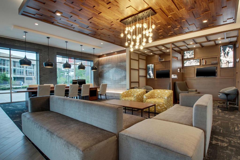 a lobby with a couch and a table and chairs at Hyatt Place Milwaukee Downtown in Milwaukee