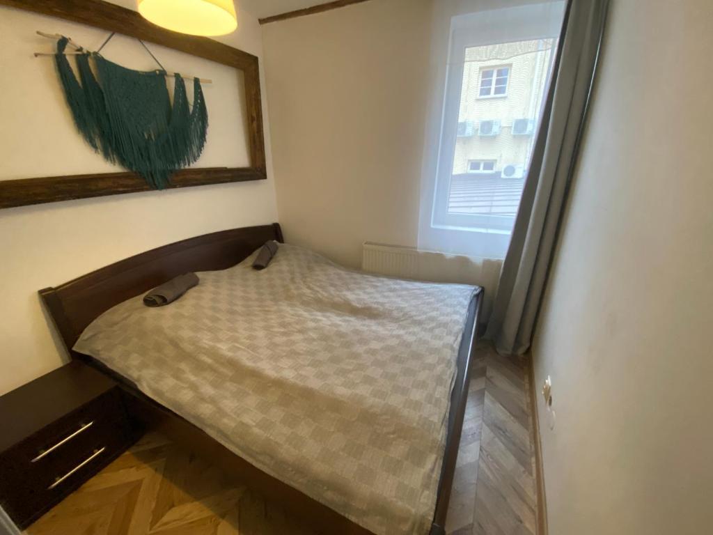 ein kleines Bett in einem kleinen Zimmer mit Fenster in der Unterkunft Historical apartments V18 in Košice