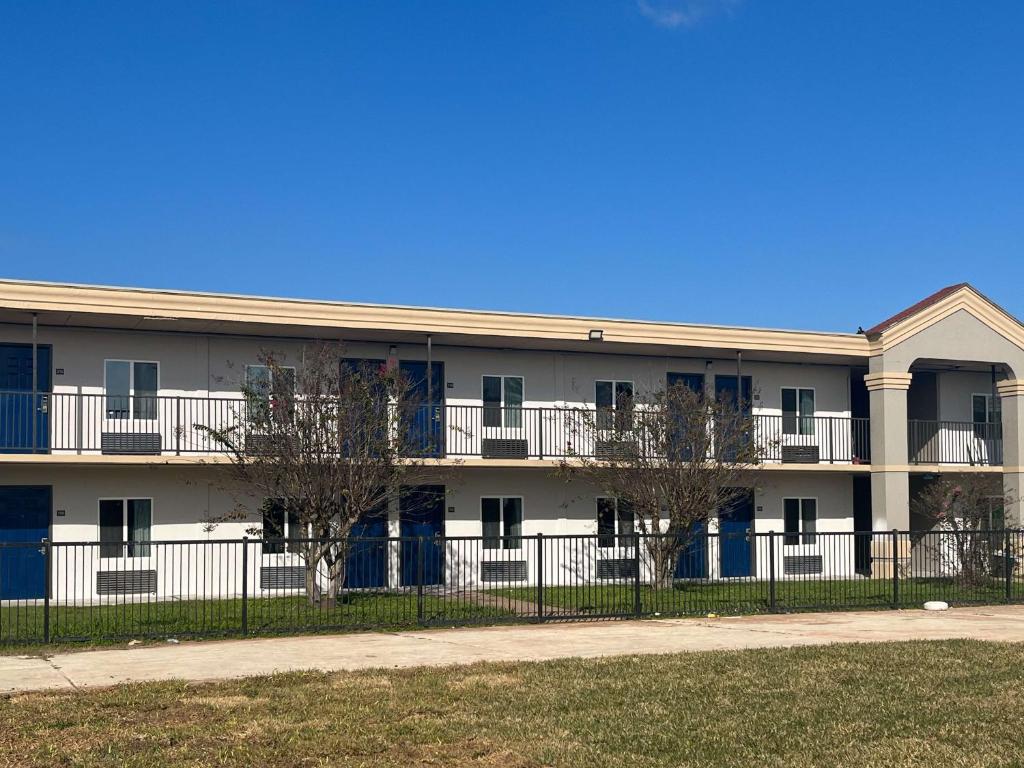 un edificio de apartamentos con una valla delante en Studio 6 Lake Jackson, TX, en Lake Jackson