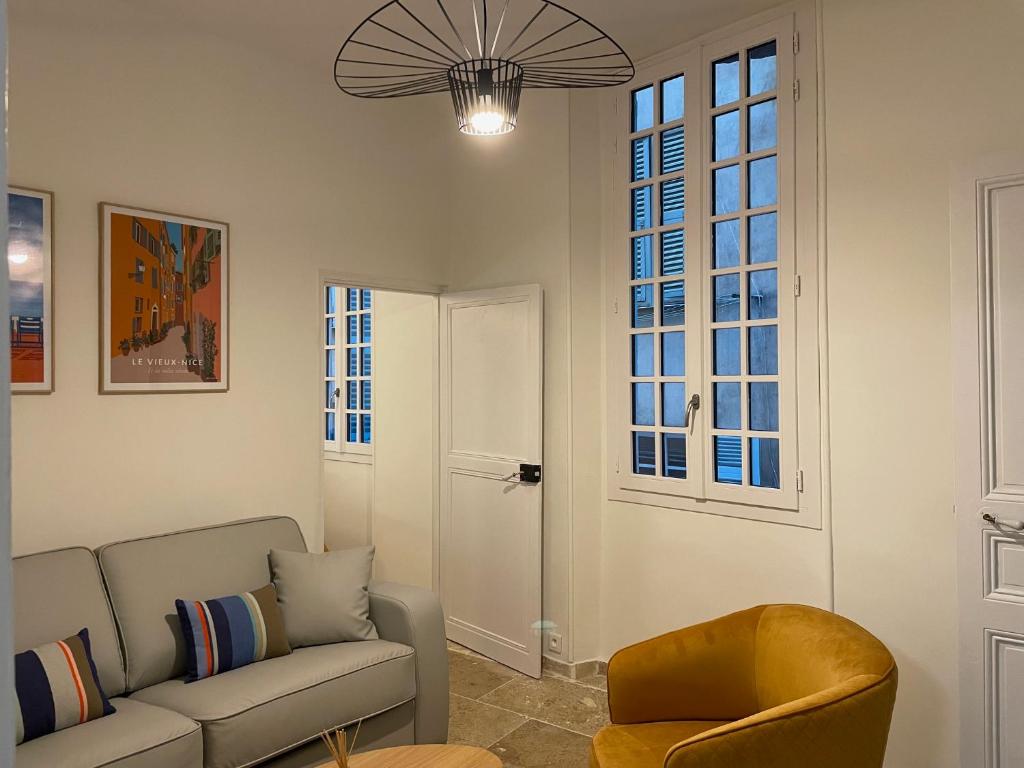 un salon avec un canapé et une chaise dans l'établissement Vieux-Nice 3 pièces confortable et calme, à Nice