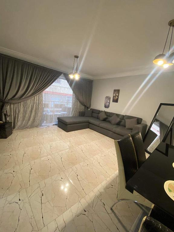 ein Wohnzimmer mit Couch und großem Fenster in der Unterkunft Corniche Glimpse in Alexandria