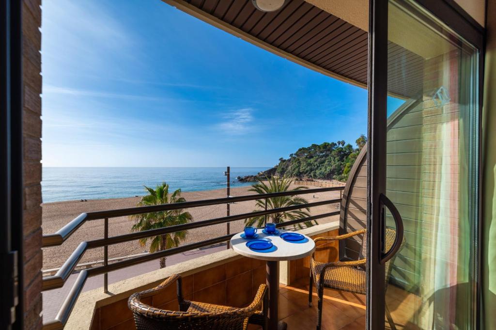 balcón con mesa y sillas y vistas a la playa en Almirall Apartaments, en Lloret de Mar