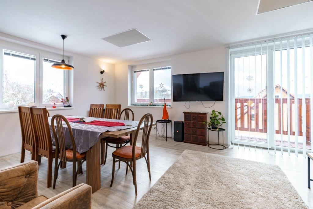 een eetkamer met een tafel en stoelen en een tv bij APARTMÁN Abertamská Chata in Abertamy