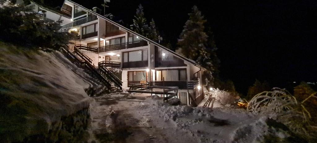 a house on a snowy hill at night at Casa Bizzo in Folgarida
