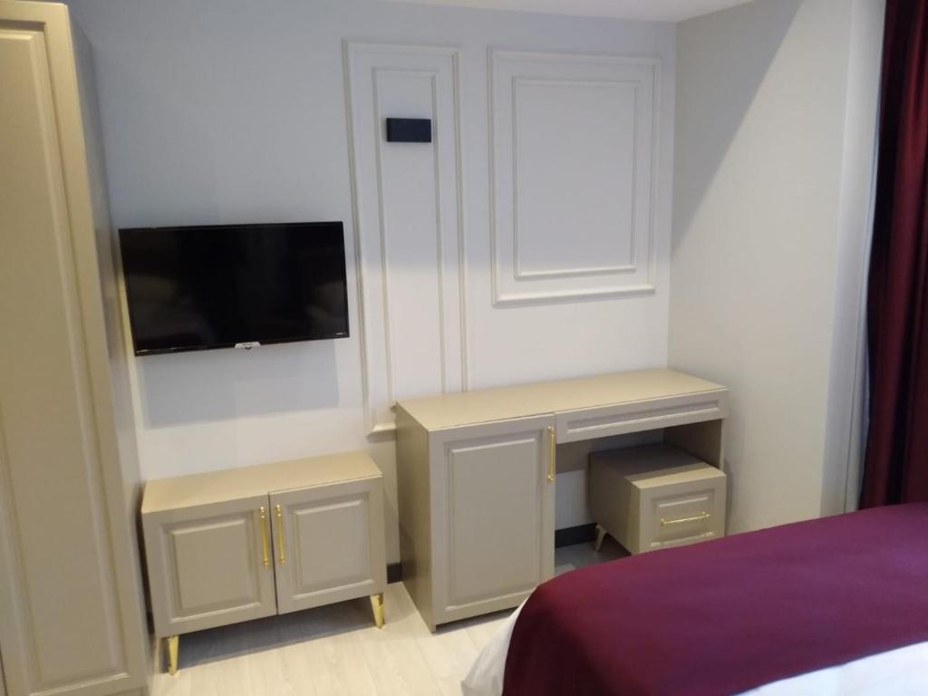 a bedroom with a bed and a desk and a tv at Eyüp Sultan Hotel in Istanbul