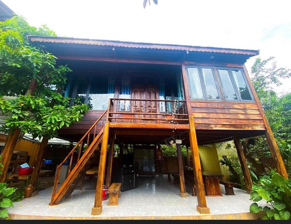 a house with a balcony on top of it at Gỗ Homestay khu sinh thái Akodhong và trung tâm BMT in Buon Ma Thuot