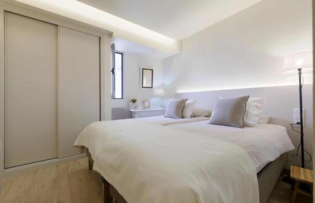 1 dormitorio blanco con 2 camas y ventana en Apartamentos do Mar - Pikis Flat, en Funchal