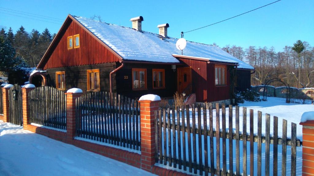 a small house with a fence in the snow at Chalupa Střítež in Vělopolí