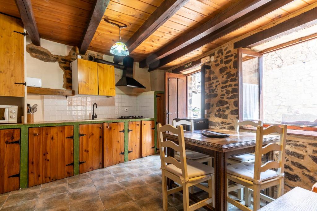 cocina con mesa de madera y algunas sillas en Casa de turismo rural Sardom3 en Bembibre