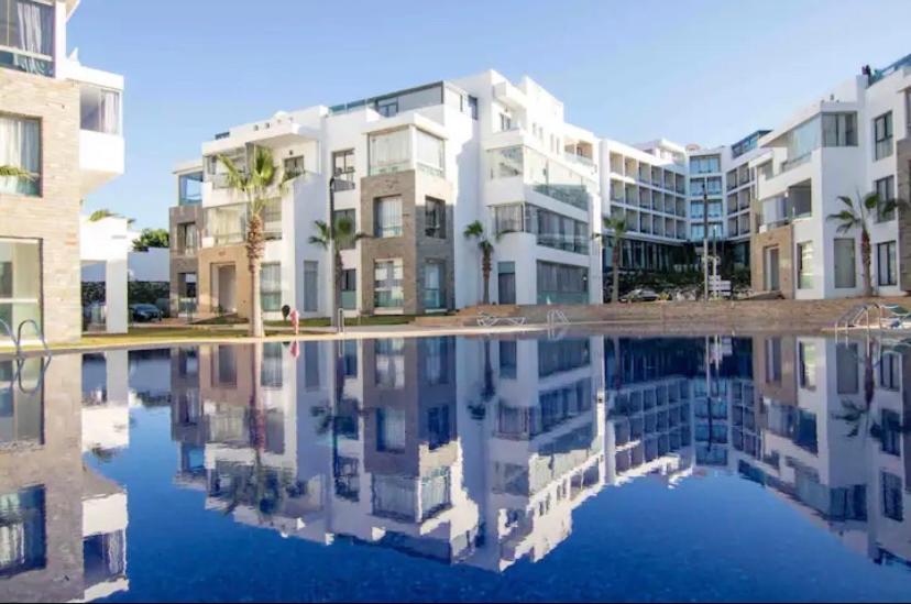 ein Gebäude mit Reflexion in einem Wasserpool in der Unterkunft résidence hivernage Quartier Sonaba in Agadir