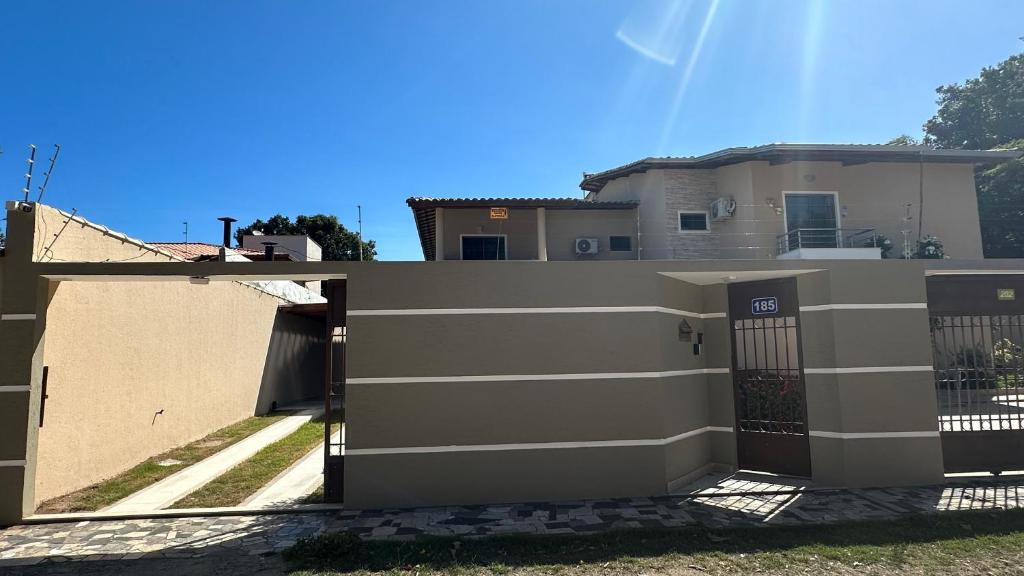 a house with a fence in front of it at Recanto Ville House in Porto Seguro