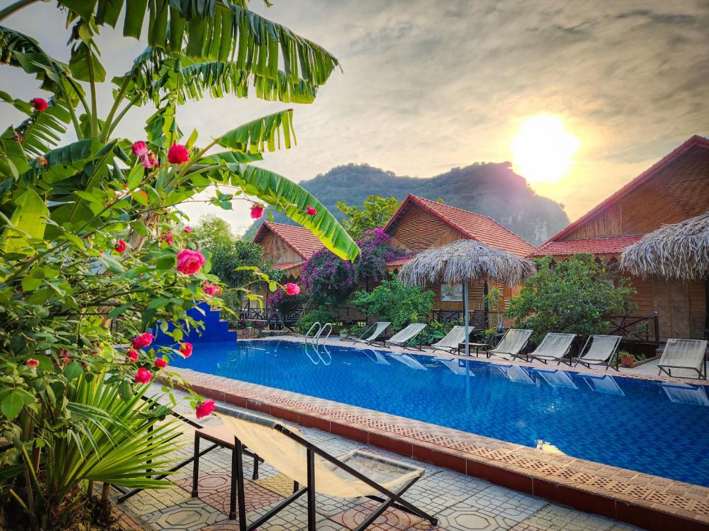 a pool at a resort with chairs and flowers at Trang An Quynh Trang Happy Homestay & Garden in Ninh Binh