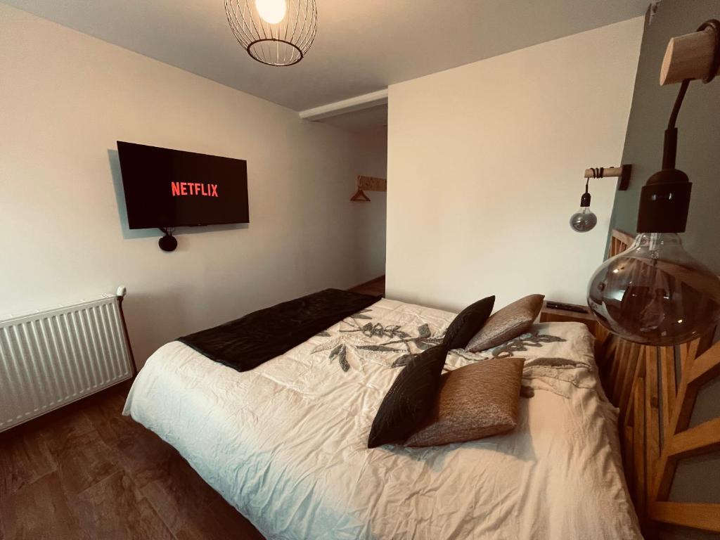 a bedroom with a bed and a tv on the wall at Chez Gabriel et Sophie in Pérouges