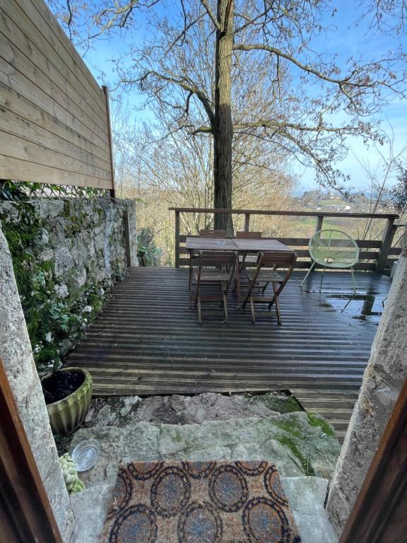 a wooden deck with a table and chairs on it at Chez Gabriel et Sophie in Pérouges