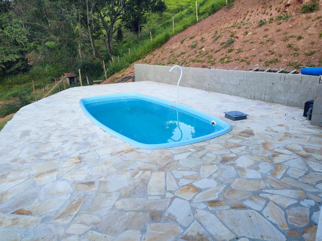 a swimming pool with a water fountain on a patio at Casa de campo com piscina a 2 min de cunha in Cunha