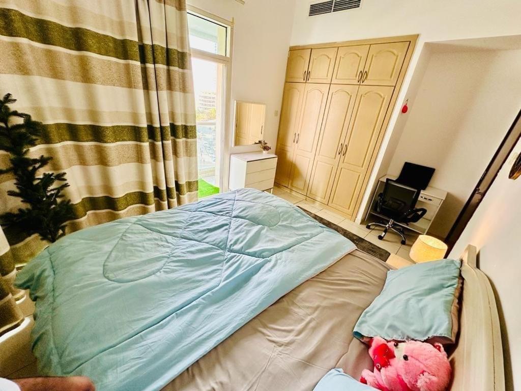 a bedroom with a bed with a teddy bear on it at Deluxe GIRLS HOSTEL in Dubai