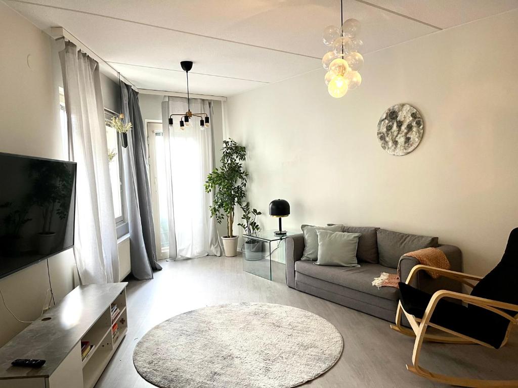 a living room with a couch and a tv at Central 2 Br in Tampere