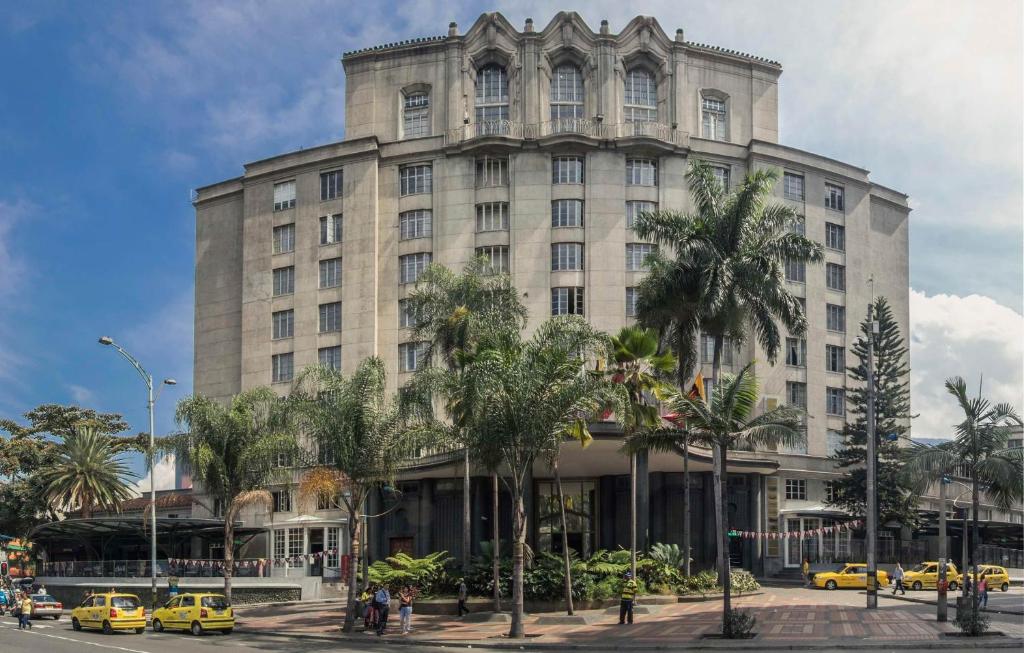 um grande edifício com palmeiras em frente em Hotel Nutibara em Medellín