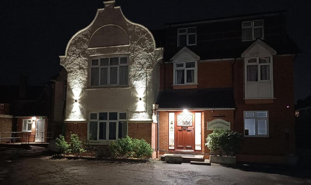 een gebouw met een verlichte deur 's nachts bij Gainsborough Lodge in Horley