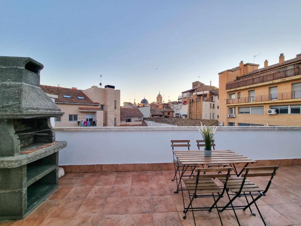 d'une terrasse sur le toit avec une table et des chaises. dans l'établissement El Alce del Pilar ComoTuCasa, à Huesca