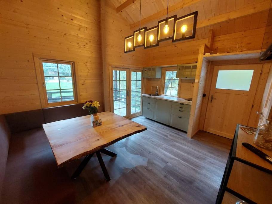 uma grande cozinha com uma mesa de madeira num quarto em Tiny House am Teich em Garnsdorf