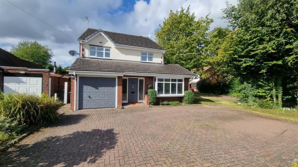 a house with a garage and a driveway at Bluebell House Home in country village. NEC/Stratford/Birmingham in Solihull