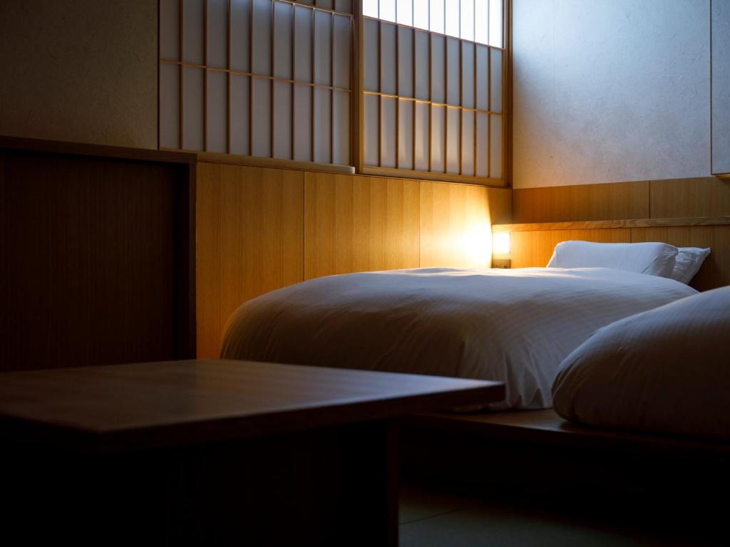 Postel nebo postele na pokoji v ubytování 黒梅屋 Kurumiya