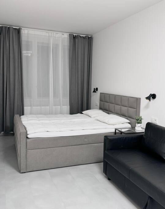 ein Schlafzimmer mit einem großen Bett und einem Sofa in der Unterkunft NEW Modern Large Apartment in New Town 3BDR in Prag