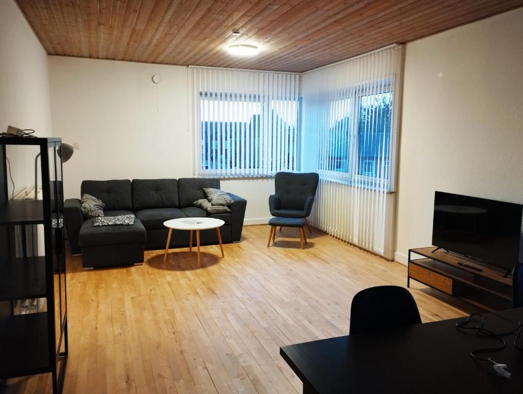 (Id022) Strandby Kirkevej 270 1 th في إيسبيرغ: غرفة معيشة مع أريكة وطاولة وكراسي