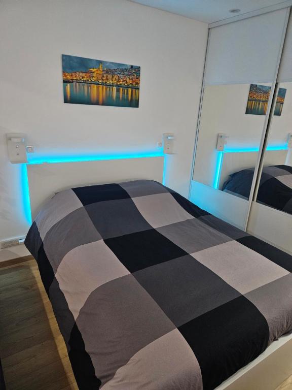 a bedroom with a black and white bed and a mirror at Lovely appartement near sea and Monaco with free parking in Roquebrune-Cap-Martin