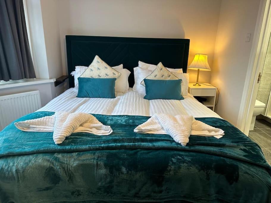uma cama com almofadas azuis e brancas em Adam’s Place, Watford WD17 2PY (near Harry Potter) em Watford